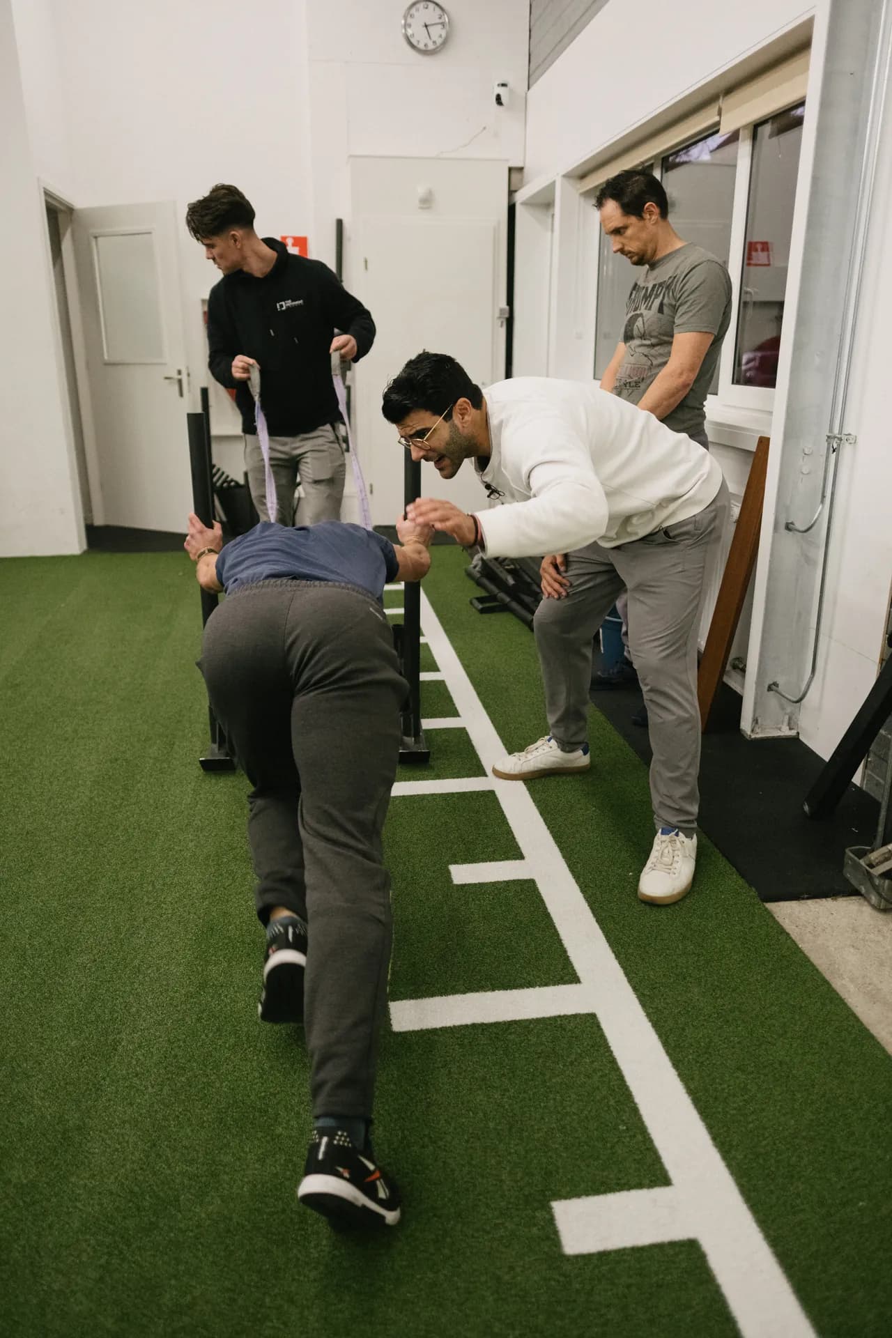Richard Aceves coaching a coach through an assisted sled drag