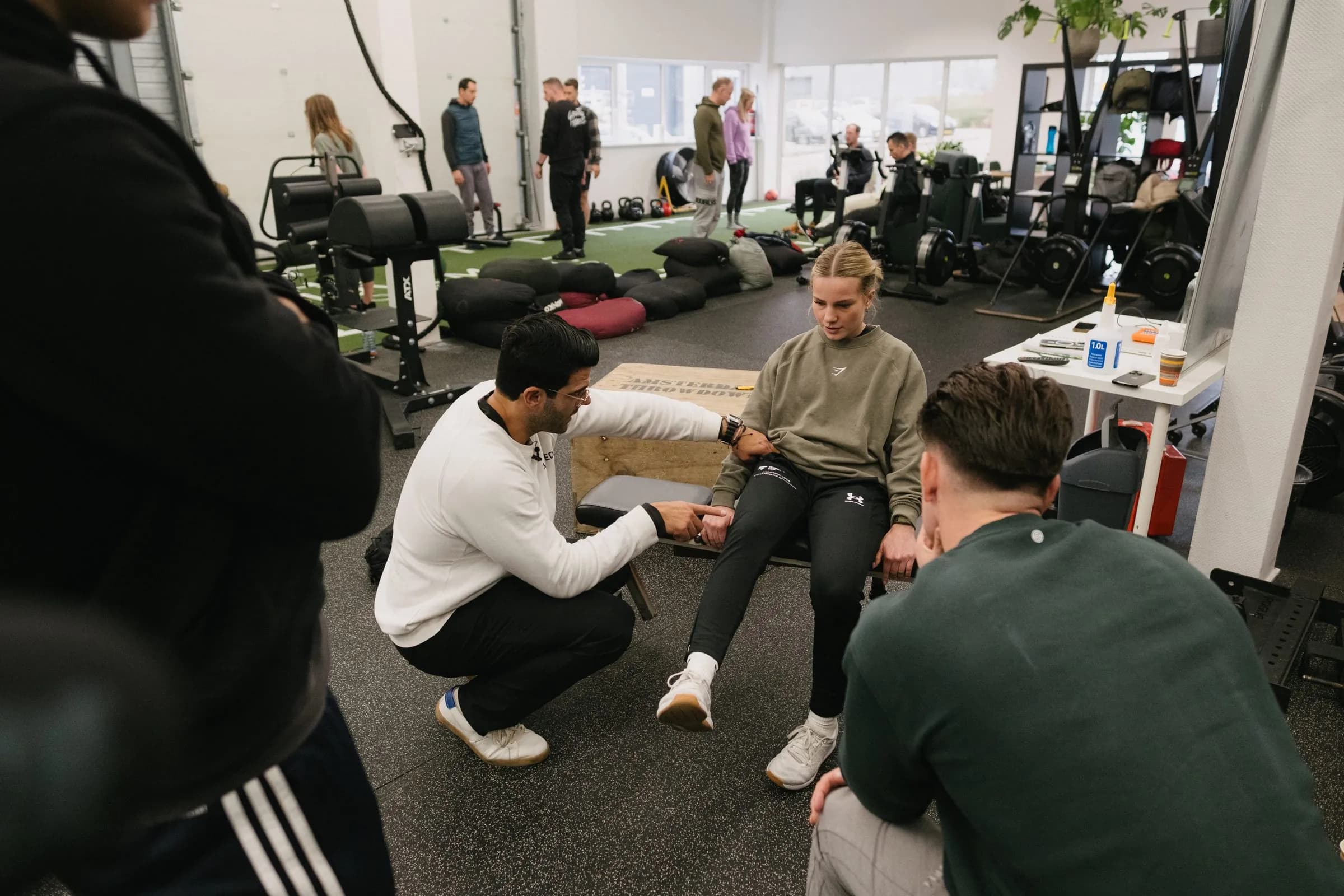 Richard Aceves demonstrating hands-on ankle mobility work in front of a group