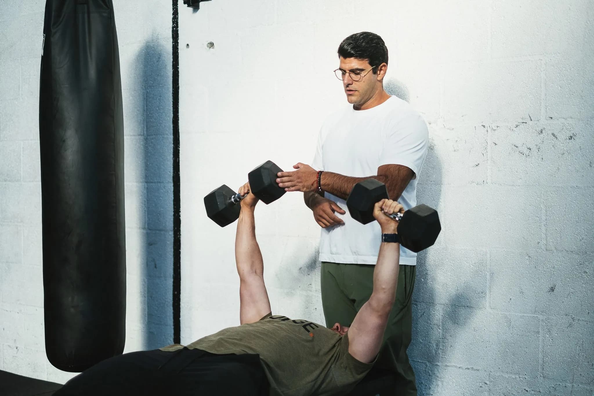 Richard Aceves coaching a client through a controlled dumbbell press