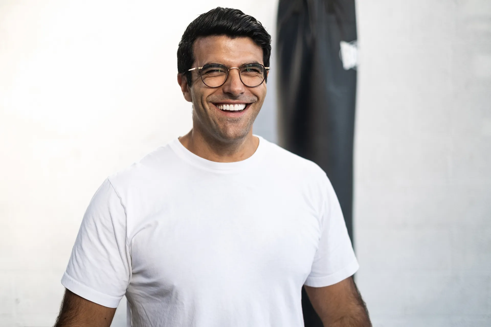 Richard Aceves laughing openly in a gym, natural light