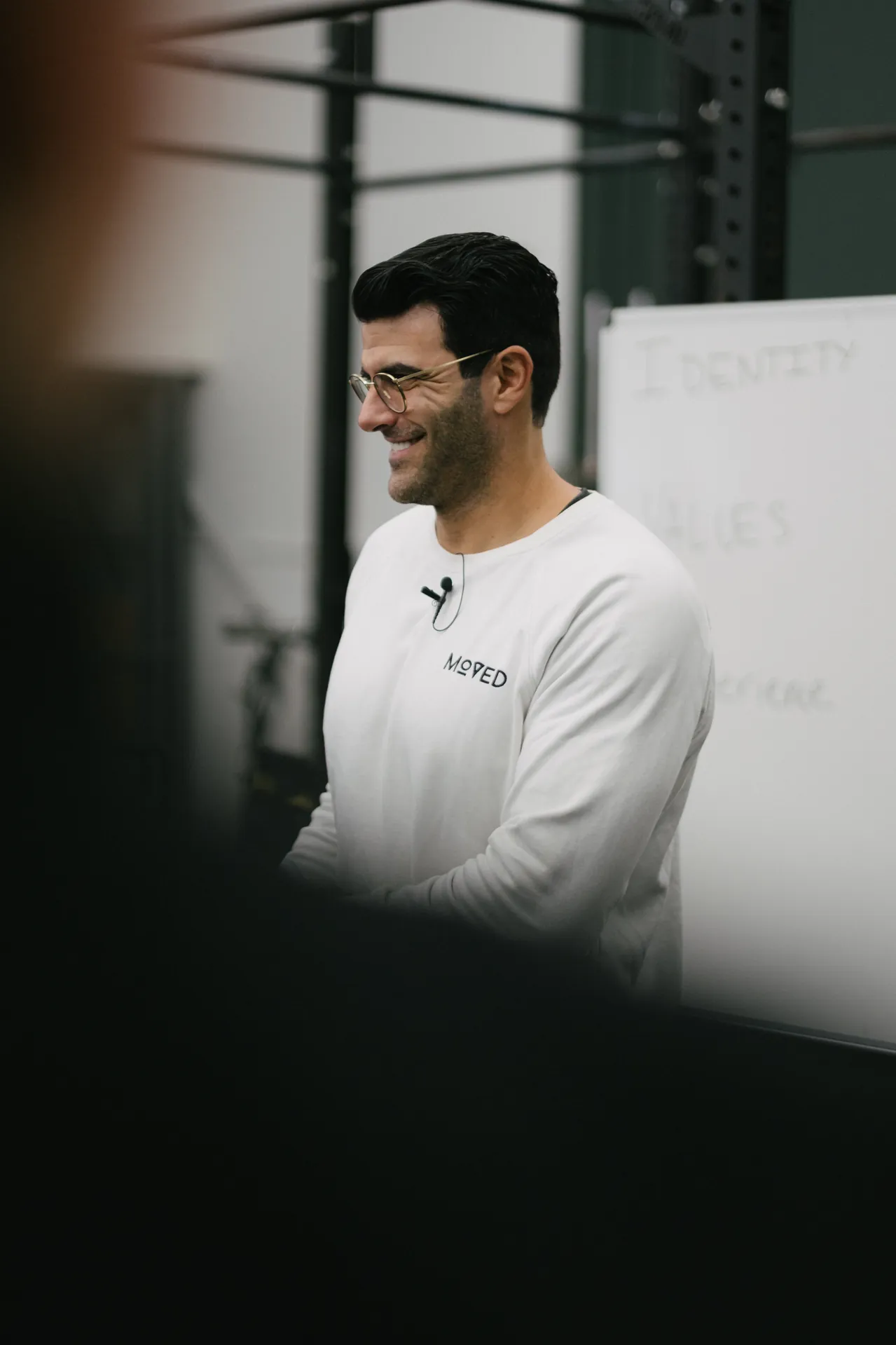 Richard Aceves smiling while teaching, a whiteboard behind him reading Identity and Values