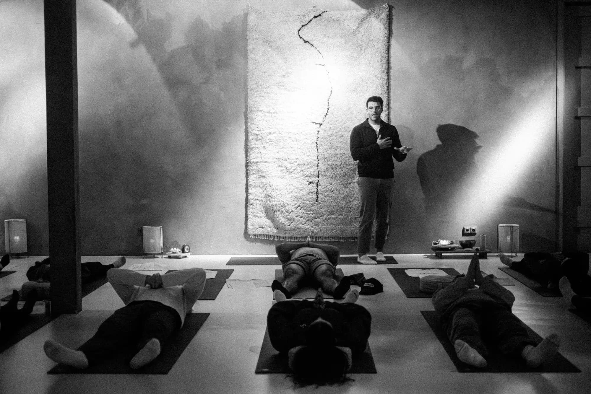 Richard Aceves teaching a Swami practice while participants lie on mats in a studio